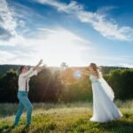 Természetközeli esküvő fiatal párral a szabadban, boldog pillanatok.